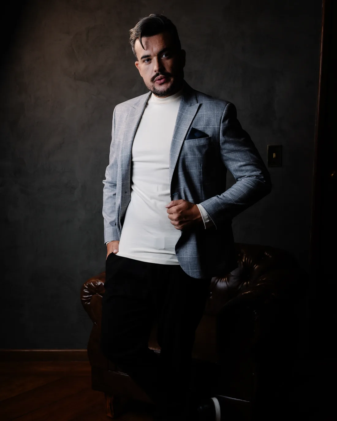Vinícius Faggundes, retrato editorial em pé com blazer cinza